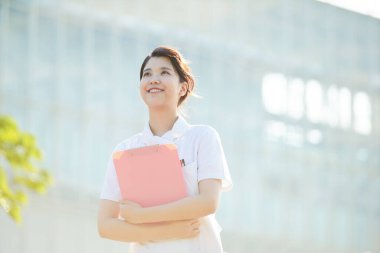 Açık havada gülümseyen Asyalı (Japon) kadın hemşire portresi