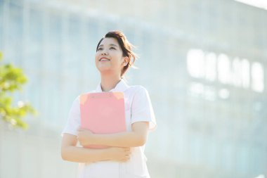 Açık havada gülümseyen Asyalı (Japon) kadın hemşire portresi