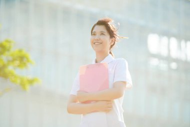 Açık havada gülümseyen Asyalı (Japon) kadın hemşire portresi