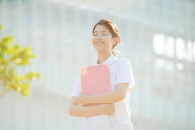 Açık havada gülümseyen Asyalı (Japon) kadın hemşire portresi