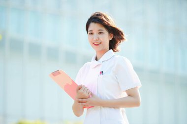 Açık havada gülümseyen Asyalı (Japon) kadın hemşire portresi