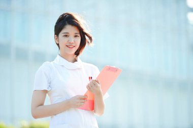 Açık havada gülümseyen Asyalı (Japon) kadın hemşire portresi