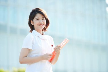 Açık havada gülümseyen Asyalı (Japon) kadın hemşire portresi