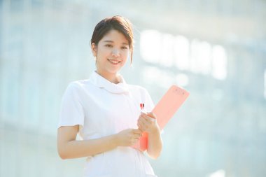 Açık havada gülümseyen Asyalı (Japon) kadın hemşire portresi