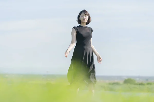 海のそばの公園で黒い服を着たアジア系の若い女性 — ストック写真