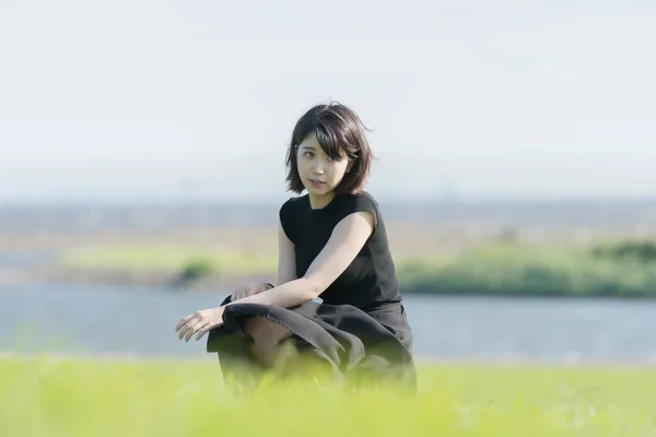 Deniz Kenarındaki Bir Parkta Siyah Elbiseli Asyalı Genç Bir Kadın — Stok fotoğraf