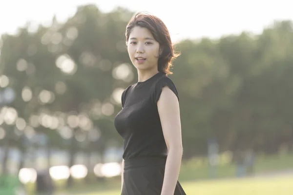 Deniz Kenarındaki Bir Parkta Siyah Elbiseli Asyalı Genç Bir Kadın — Stok fotoğraf