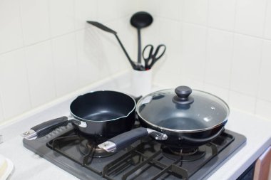 Mutfak gaz ocağına konmuş tencere ve tava gibi mutfak aletleri