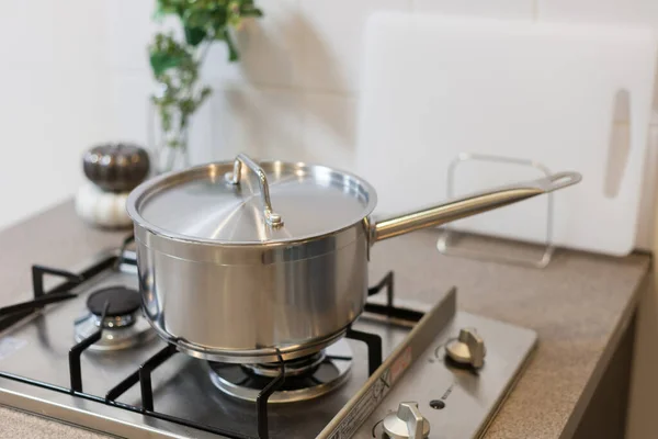 Kitchen tools such as pots and pans set on the kitchen gas stove