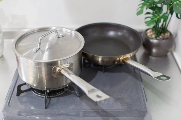 Kitchen tools such as pots and pans set on the kitchen gas stove