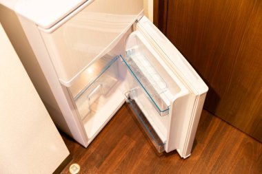 Oturma odasının mutfağına yerleştirilmiş beyaz buzdolabı.