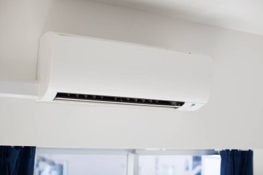 White air conditioner installed in a room in a house clipart