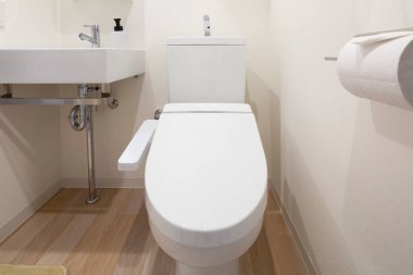 Çamaşır dolabındaki beyaz temiz tuvaletin bir fotoğrafı.