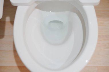 Çamaşır dolabındaki beyaz temiz tuvaletin bir fotoğrafı.