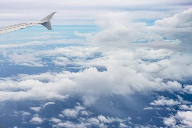 Gökyüzü ve bulutlar uçağın penceresinden görünüyor