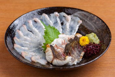 Tabağa yerleştirilmiş taze çiğ balık dilimleri.