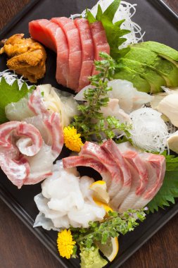 Tabağa yerleştirilmiş taze çiğ balık dilimleri.