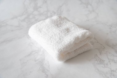 Beyaz mermerden yapılmış bir masaya yerleştirilmiş beyaz yüz havlusu.