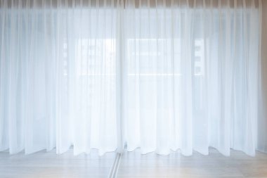 Odada parlak güneş ışığı sağlayan beyaz ince perdeler.