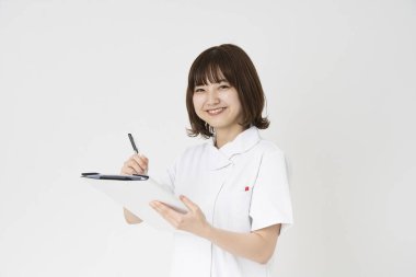 Kapalı alanda gülümseyen bir Asyalı (Japon) kadın hemşire portresi