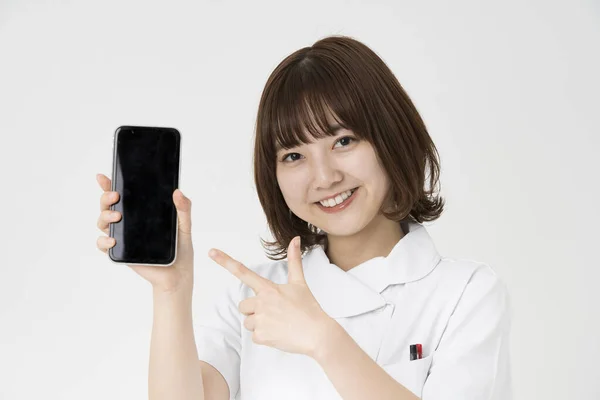 Ασιάτισσα Ιαπωνική Νοσοκόμα Που Δείχνει Μια Οθόνη Smartphone Χαμόγελο — Φωτογραφία Αρχείου