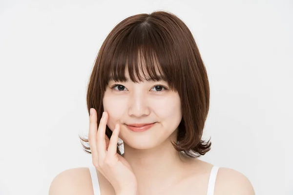 肌の状態を確認するために手で顔に触れるアジアの若い女性 — ストック写真
