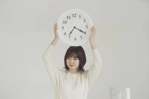 Souriant Asiatique Jeune Femme Tenant Horloge Murale Blanche Sur Tête — Photo