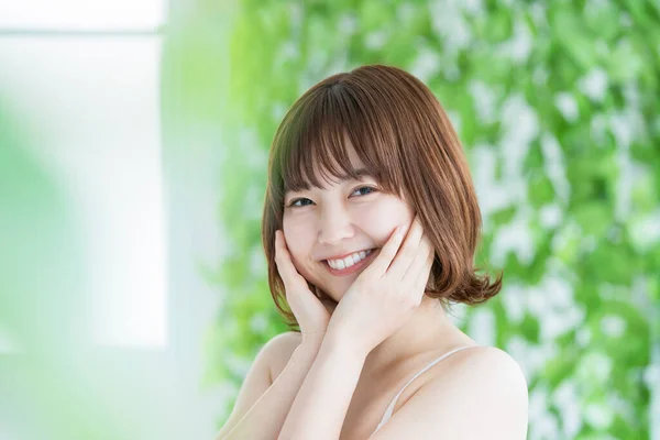 緑に囲まれた美しい肌をしたアジア系の若い女性 — ストック写真