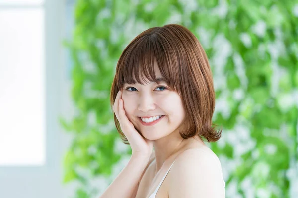 緑に囲まれた美しい肌をしたアジア系の若い女性 — ストック写真