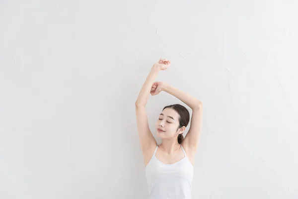 アジアの若い女性が明るい部屋で穏やかな運動をして — ストック写真