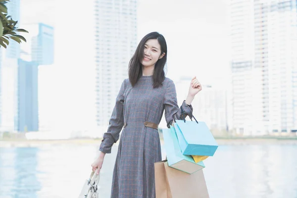 色々な色のショッピングバッグがたくさんある笑顔アジアの若い女性 — ストック写真
