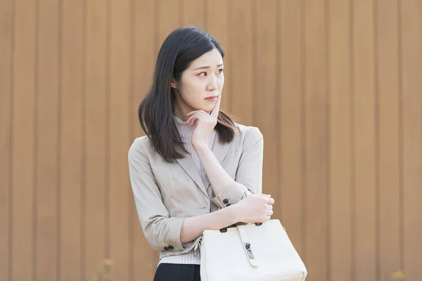 アジア系 日本人 の若い女性社員が悩ましい表情をしている — ストック写真
