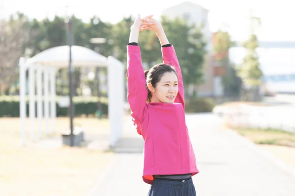 Asian young business woman exercising in the city center on a sunny day