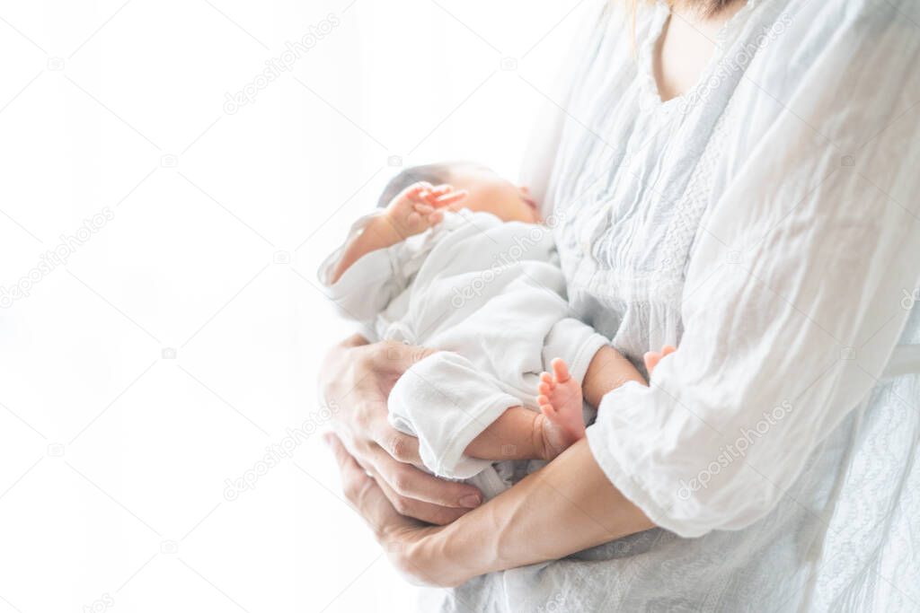A mother carrying an Asian (Japanese) newborn baby (0 year old 0 month old)