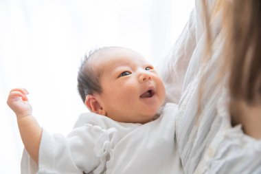 Yeni doğmuş bir Asyalı (Japon) bebeği taşıyan bir anne (0 yaşında) 0 aylık)
