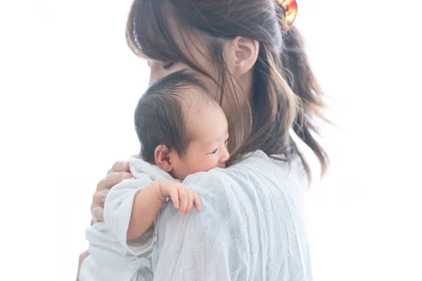 Yeni doğmuş bir Asyalı (Japon) bebeği taşıyan bir anne (0 yaşında) 0 aylık)
