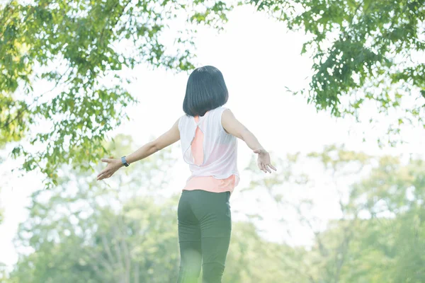 Asian woman taking a deep breath during exercise in the park