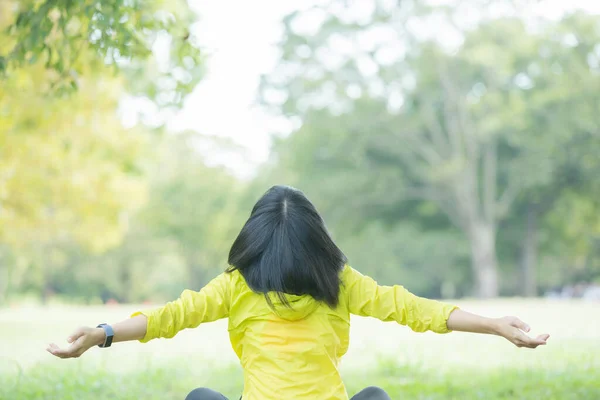 Asian woman taking a deep breath during exercise in the park