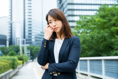 Asyalı (Japon) genç bir bayan çalışanın sıkıntılı bir ifadesi var.