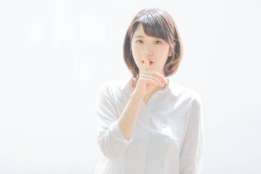 Asyalı genç bir kadın işaret parmağıyla dikkat çekiyor.