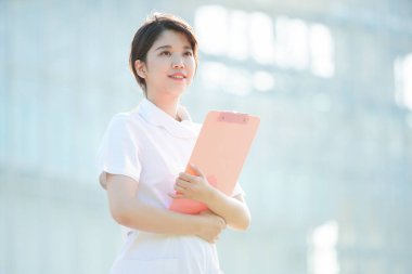 Açık havada gülümseyen Asyalı (Japon) kadın hemşire portresi