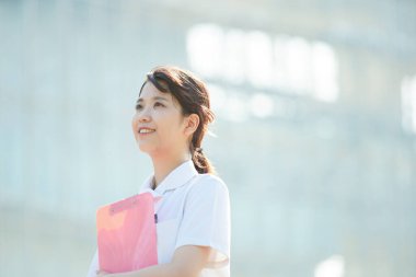 Açık havada gülümseyen Asyalı (Japon) kadın hemşire portresi