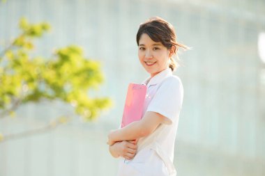 Açık havada gülümseyen Asyalı (Japon) kadın hemşire portresi