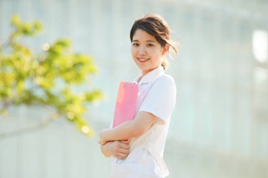 Açık havada gülümseyen Asyalı (Japon) kadın hemşire portresi