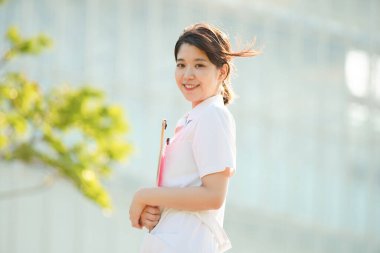 Açık havada gülümseyen Asyalı (Japon) kadın hemşire portresi