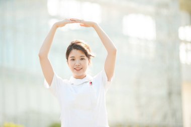 Asyalı (Japon) kadın hemşire elleri yuvarlak ve tamam işareti gösteriyor