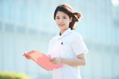 Açık havada gülümseyen Asyalı (Japon) kadın hemşire portresi