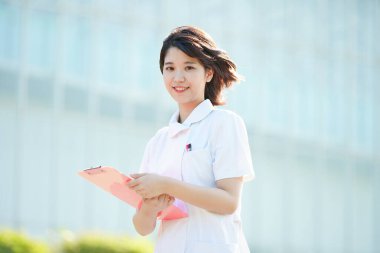 Açık havada gülümseyen Asyalı (Japon) kadın hemşire portresi