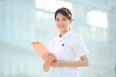 Açık havada gülümseyen Asyalı (Japon) kadın hemşire portresi