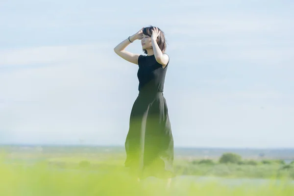 海のそばの公園で黒い服を着たアジア系の若い女性 — ストック写真